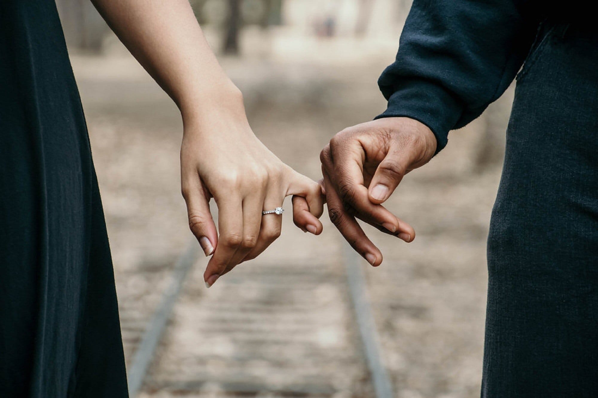 Man och kvinna krokar finger med varandra